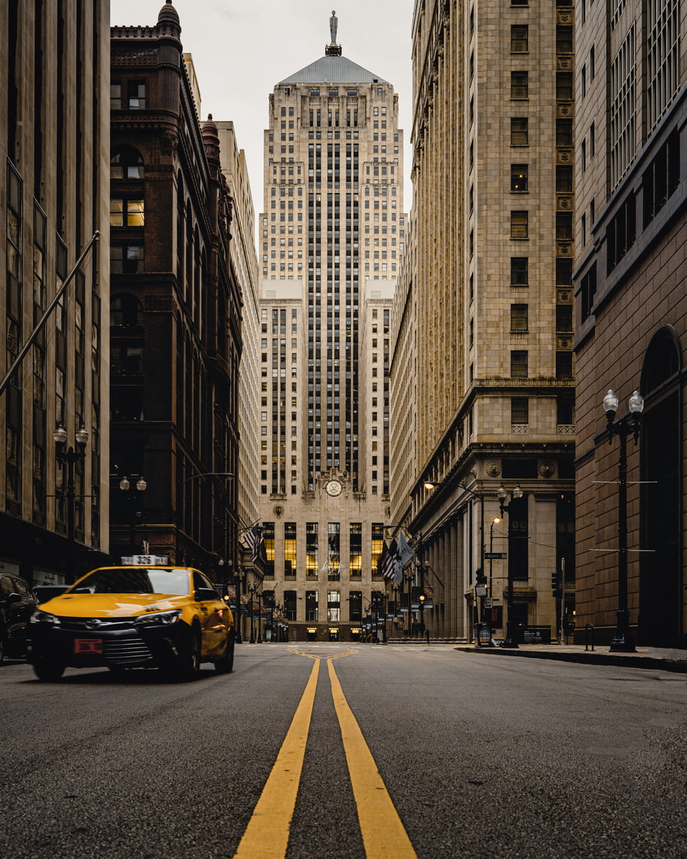Coche amarillo en la carretera entre edificios de gran altura durante el día