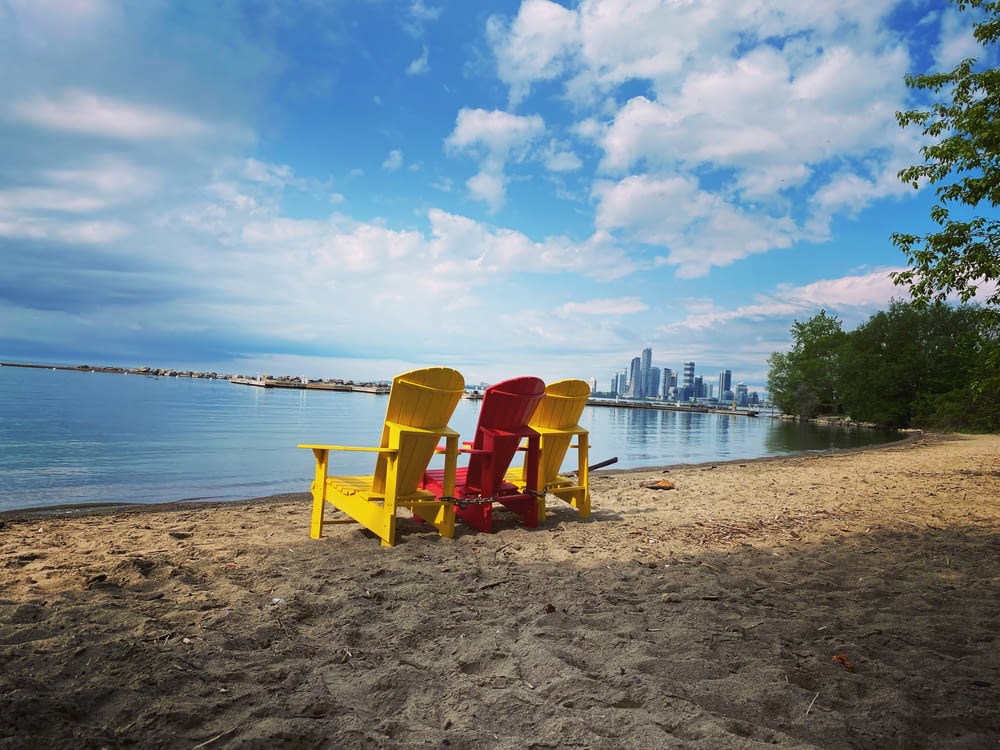 two yellow wooden folding chairs on beach shore during daytime