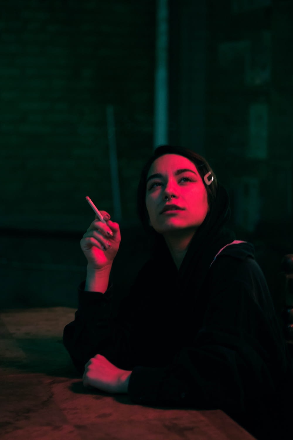 woman in black hoodie smoking cigarette