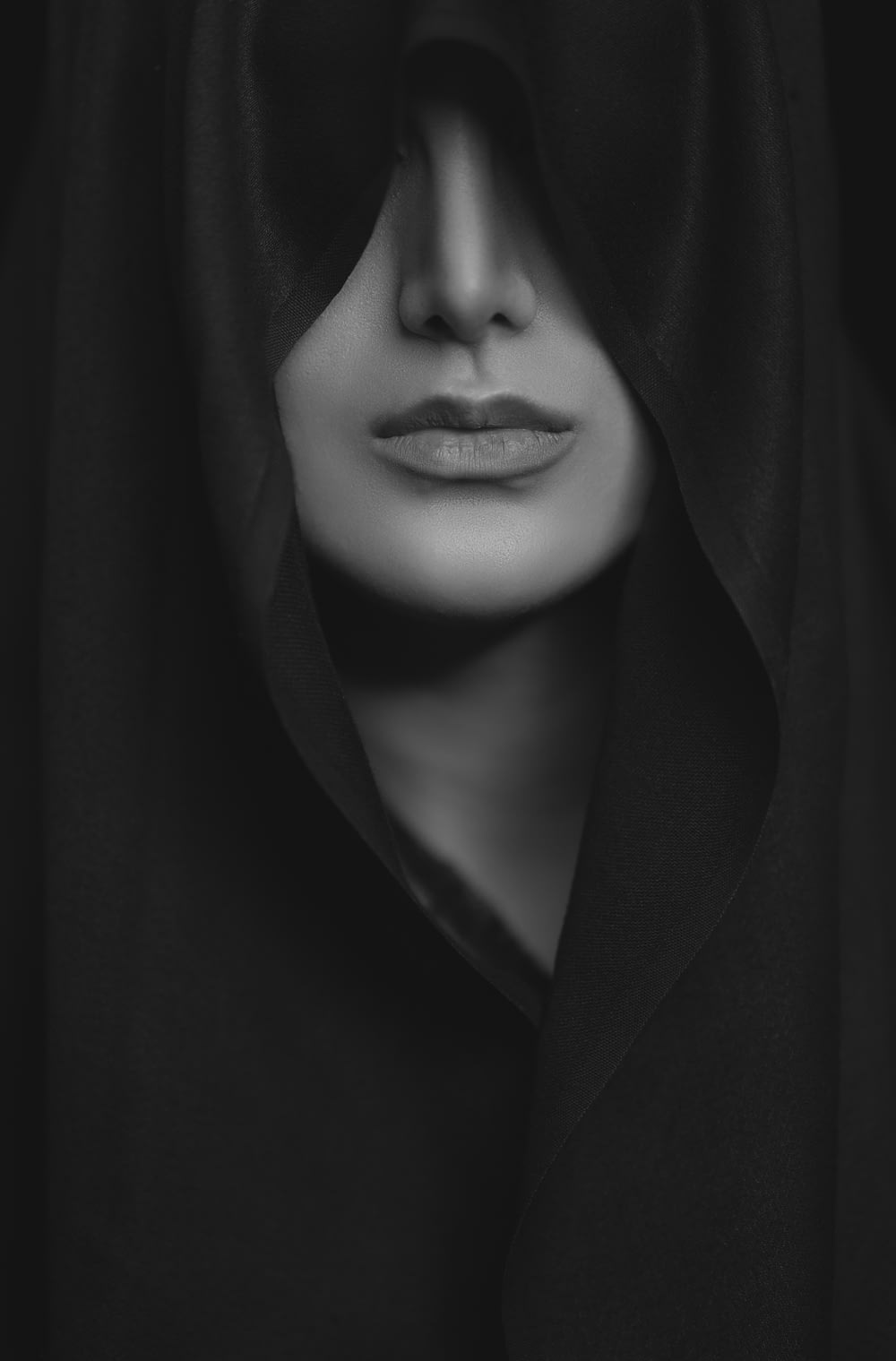 Mujer con abrigo negro en fotografía en escala de grises