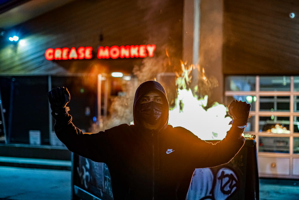 man in black hoodie holding fire