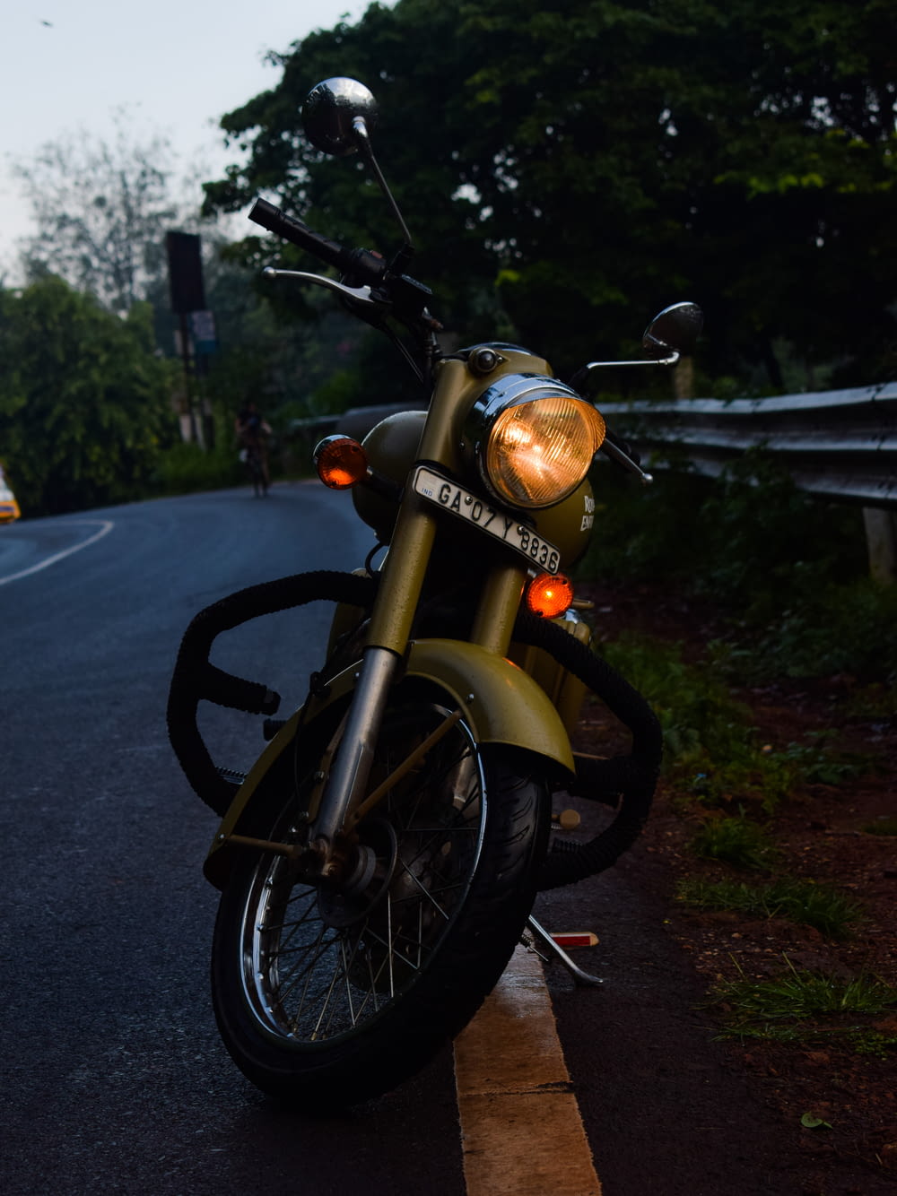 Motocicleta naranja y negra estacionada al costado de la carretera