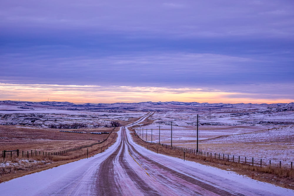Carretera cubierta de nieve durante la puesta del sol
