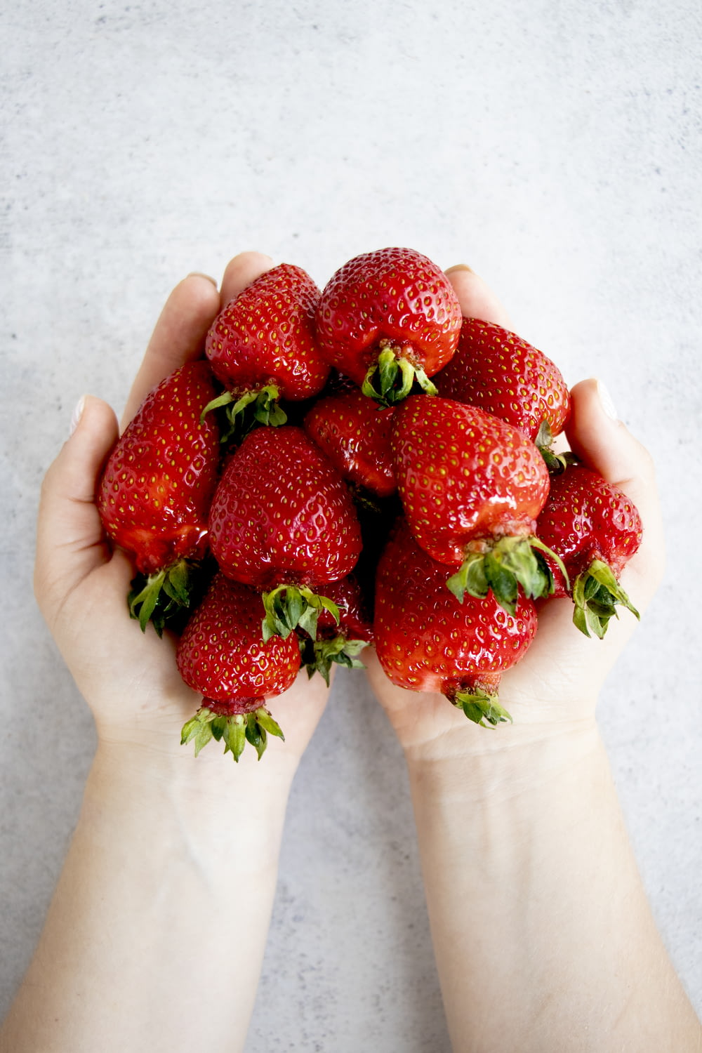 Erdbeeren an der Hand von Personen