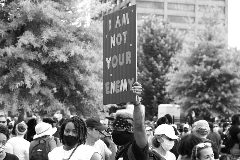 grayscale photo of people holding a signage