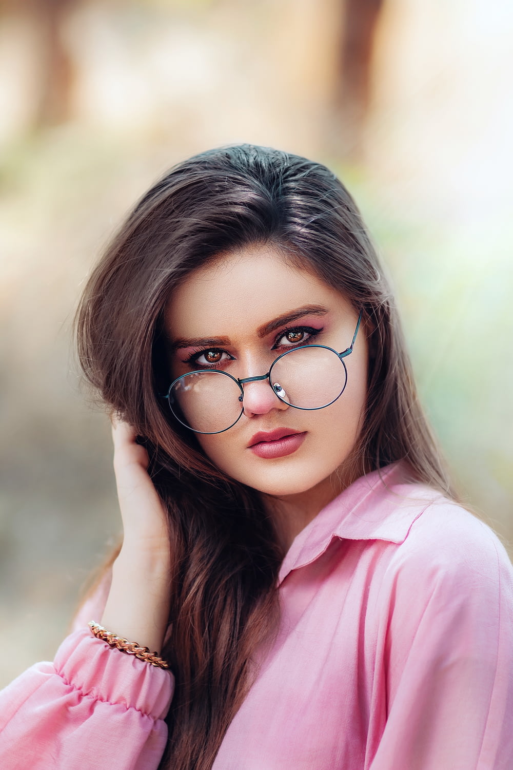 fille en chemise rose portant des lunettes à monture noire