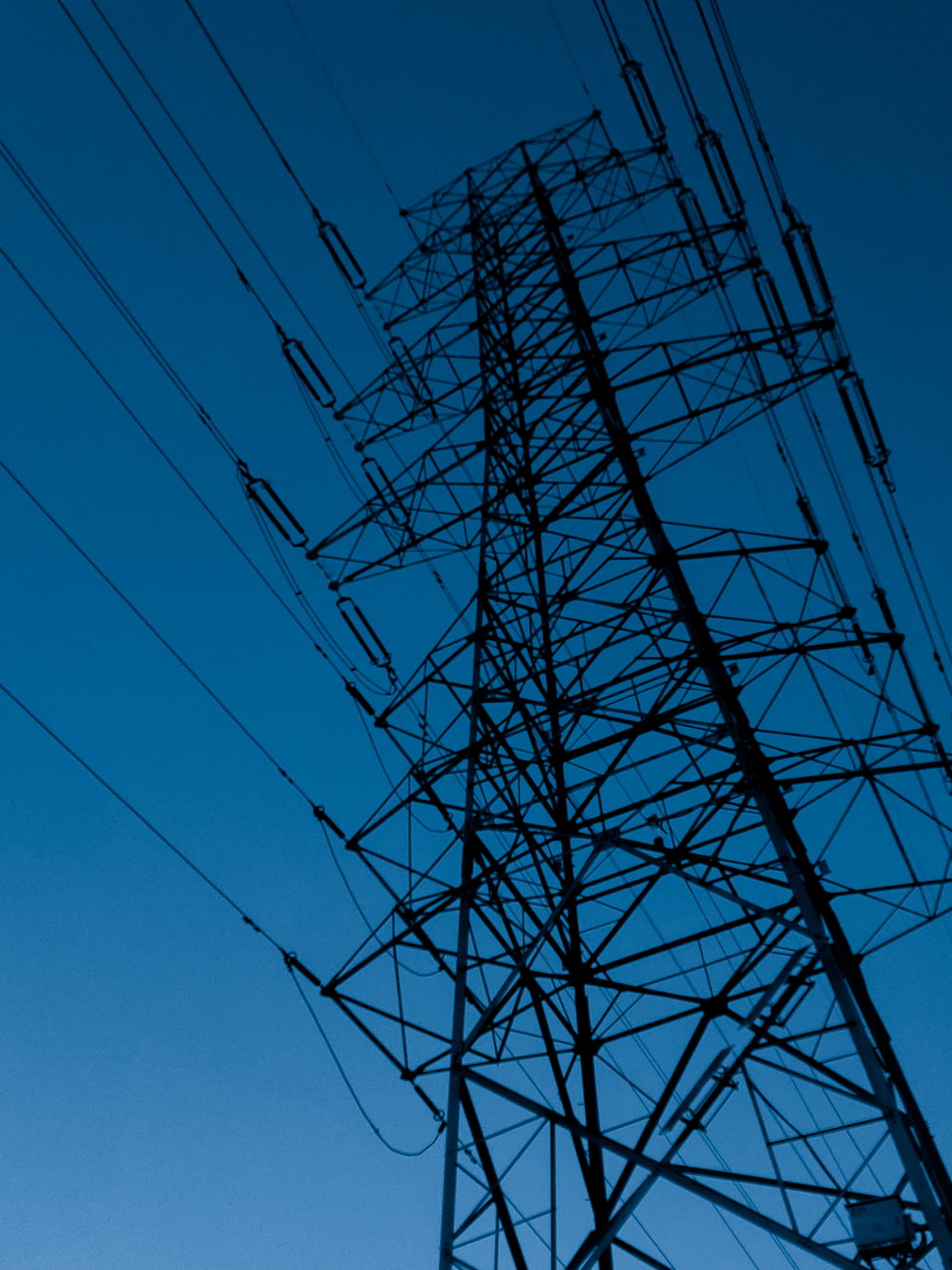 Torre elettrica nera sotto il cielo blu durante il giorno
