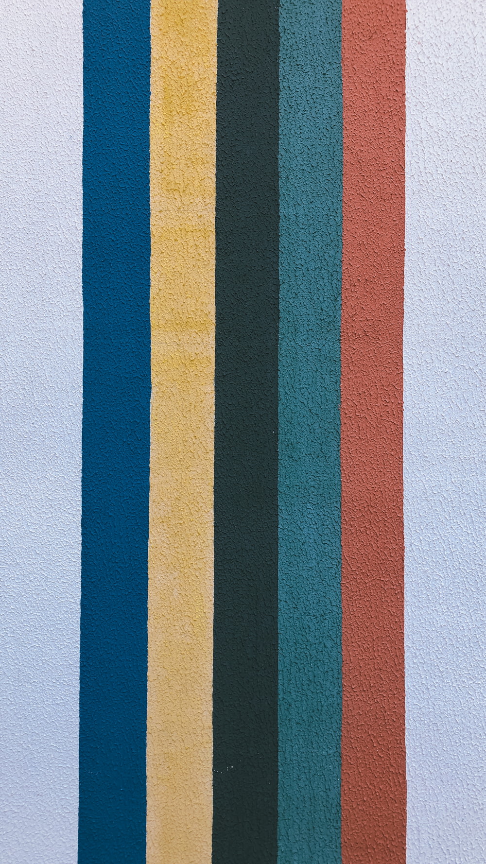 decoração de parede listrada azul amarela e vermelha