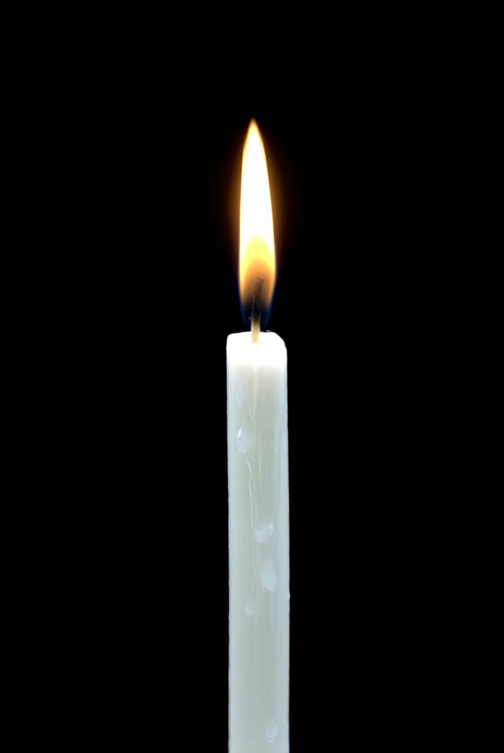 candela accesa bianca in camera oscura