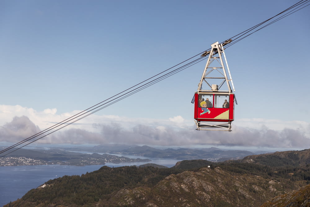 red cable car over the mountains during daytime