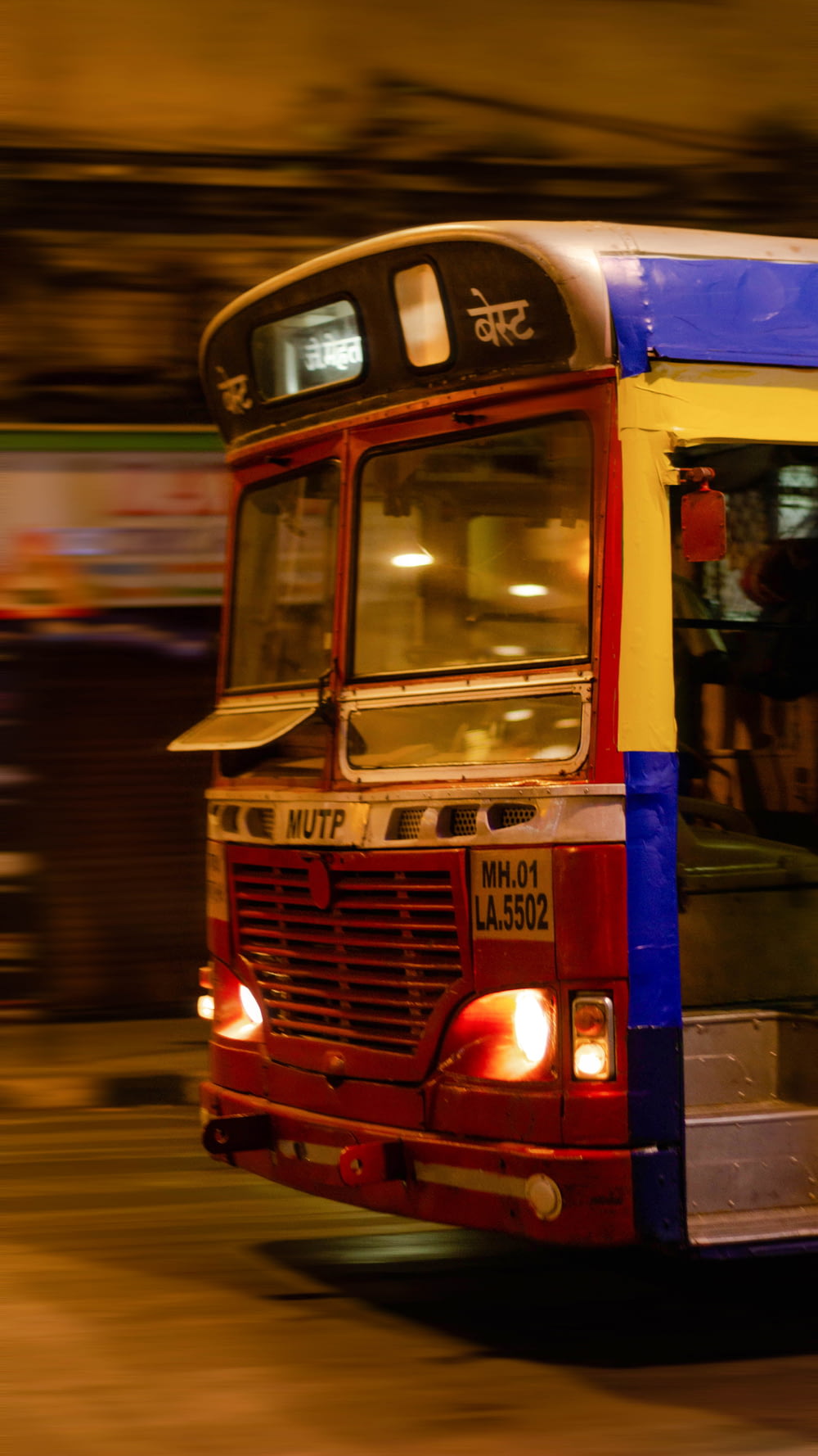 red and blue bus on the street during night time