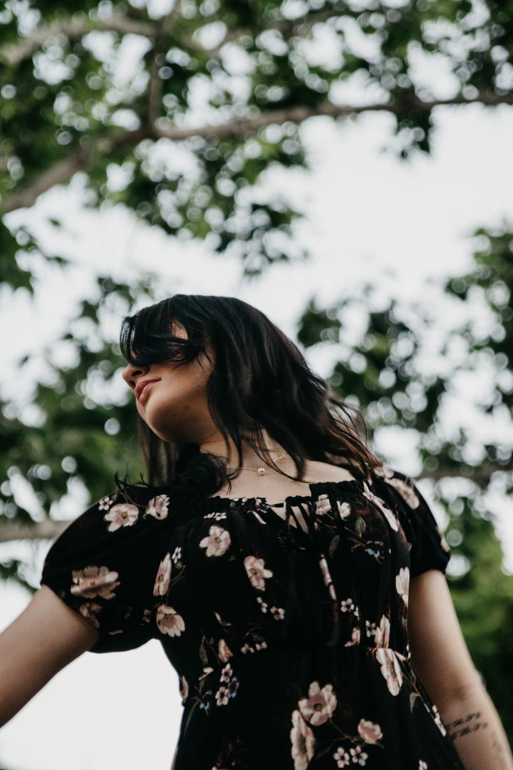 woman in black and white floral shirt wearing black sunglasses