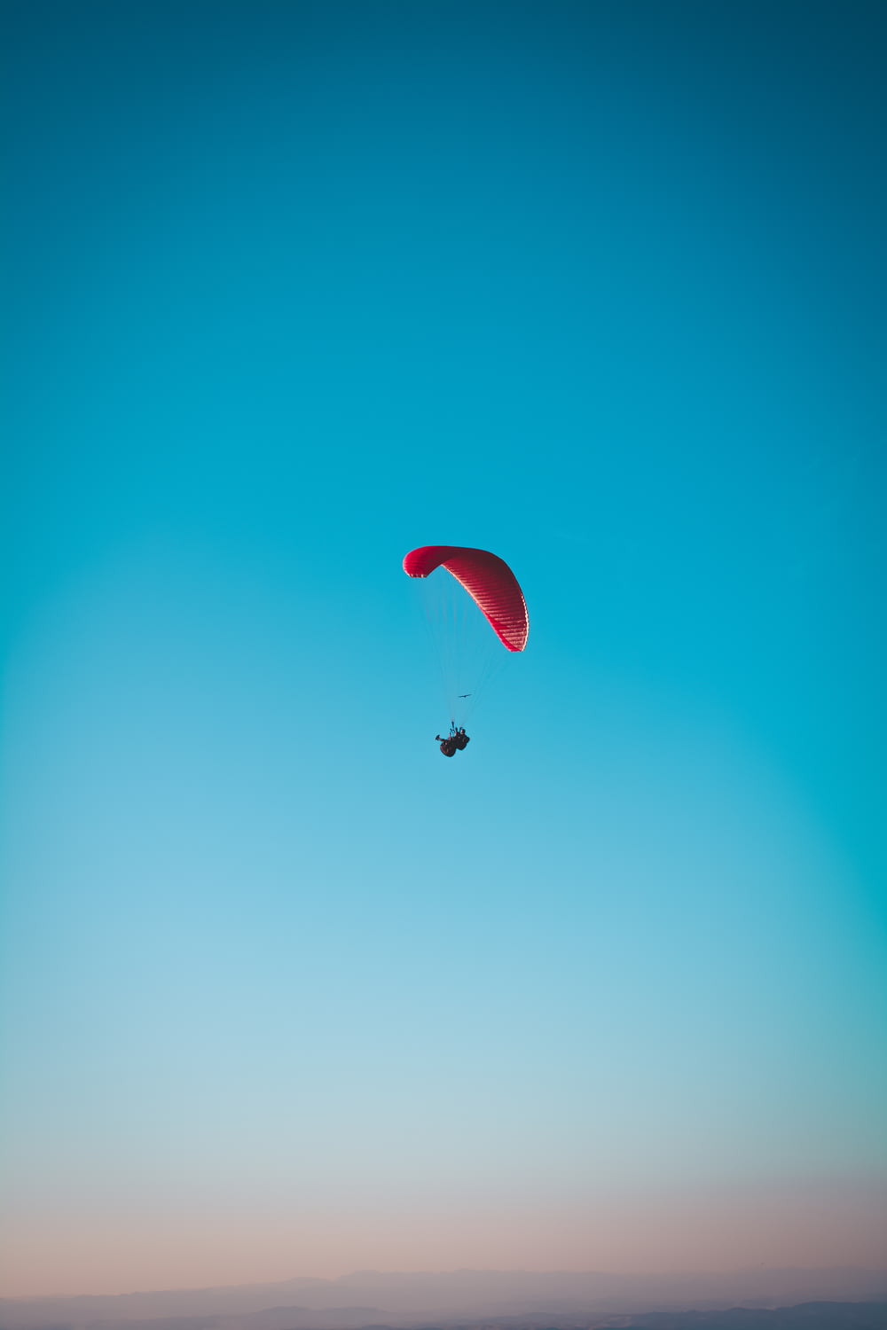 Persona en paracaídas rojo en el aire