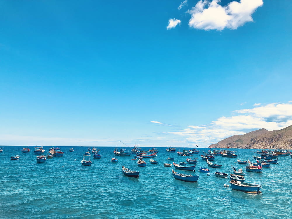 boats on sea under blue sky during daytime