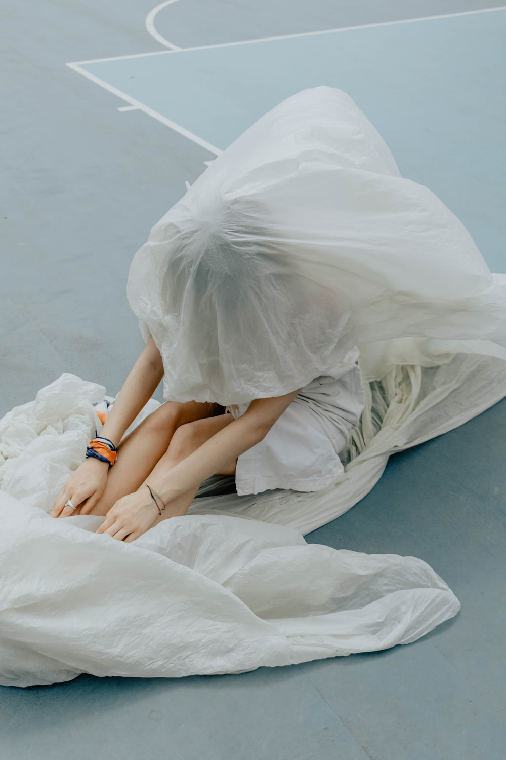 woman in white dress lying on white textile