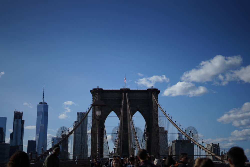 personnes marchant sur le pont sous le ciel bleu pendant la journée