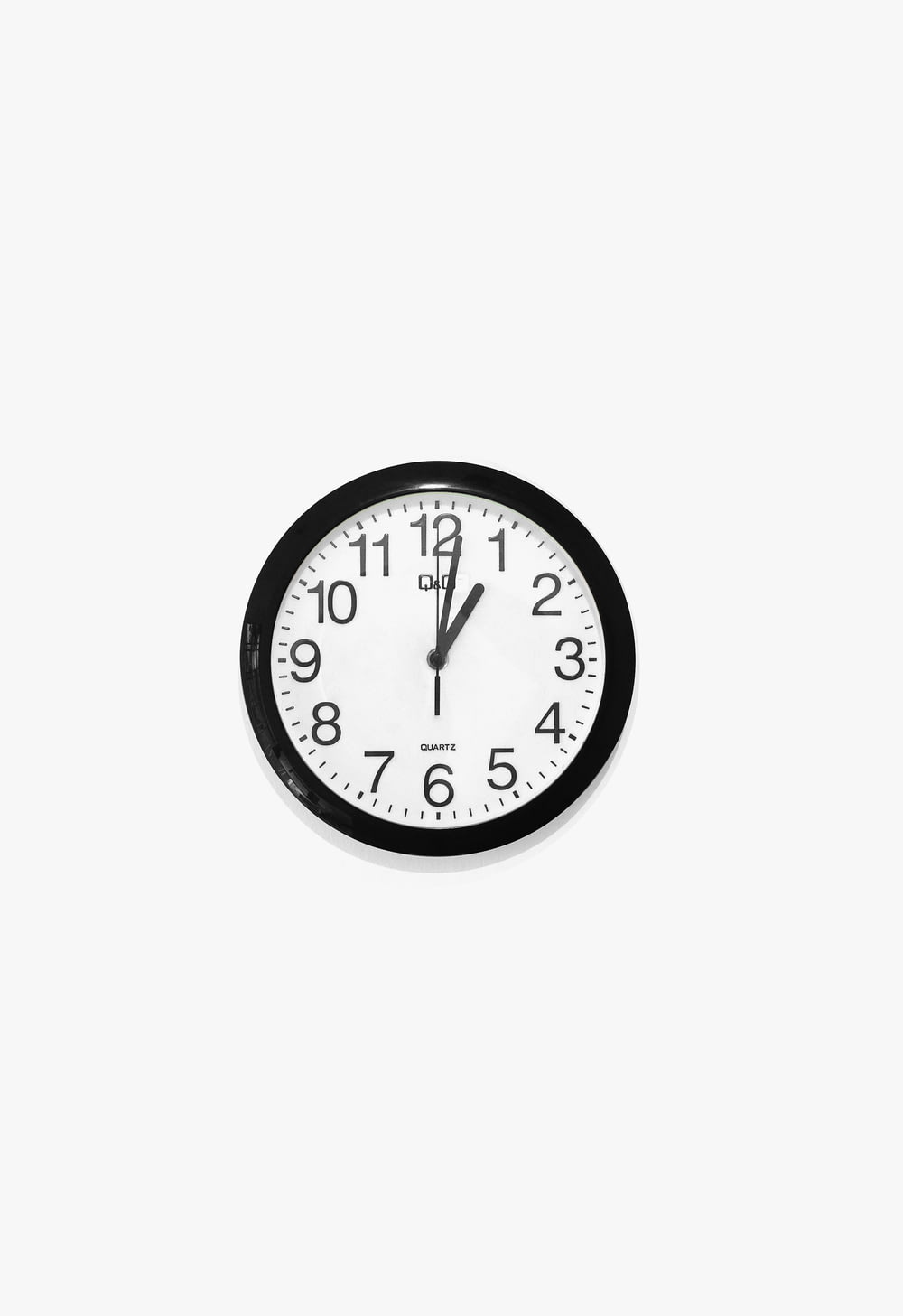 black and white round analog wall clock at 10 10