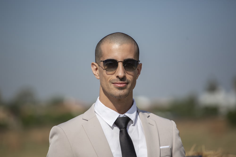 man in white suit wearing black sunglasses