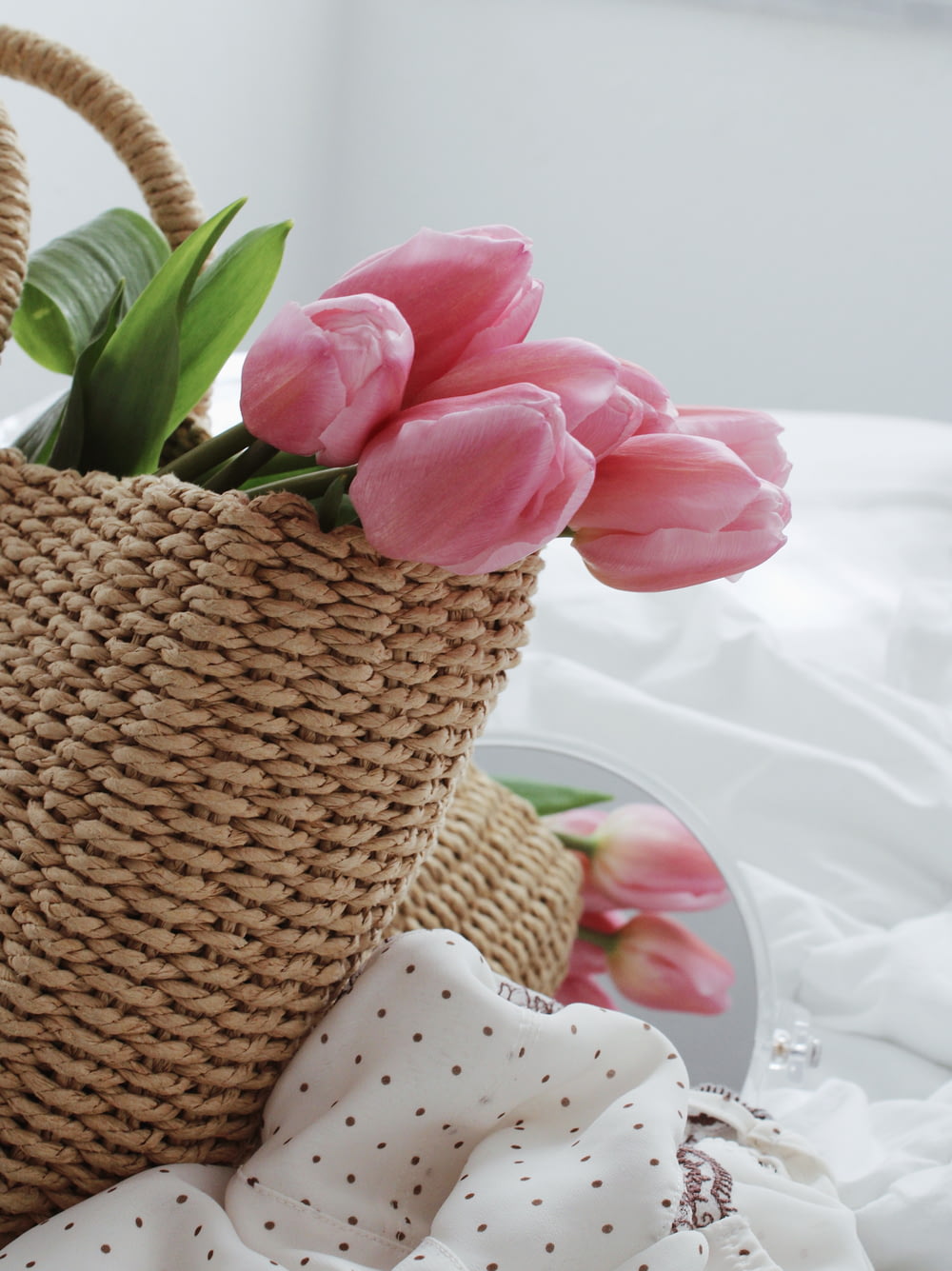 pink flower on brown woven basket