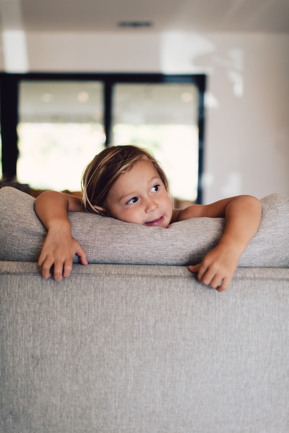 girl lying on gray couch