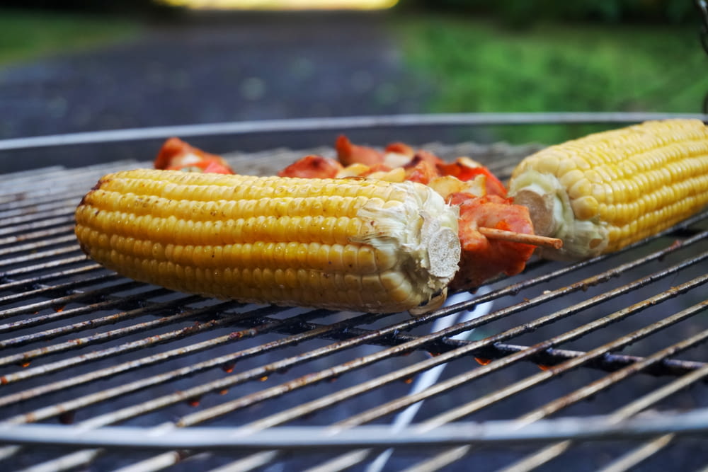 two corn on the cob on a grill