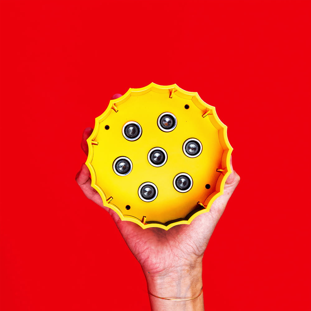 person holding green and yellow polka dot cupcake