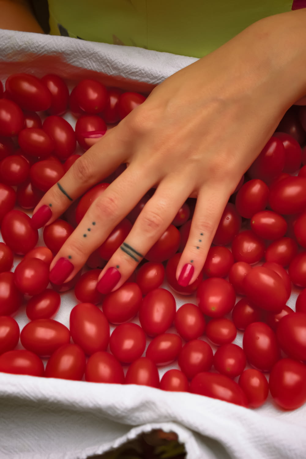Person mit roter Maniküre, die rote Tomate hält
