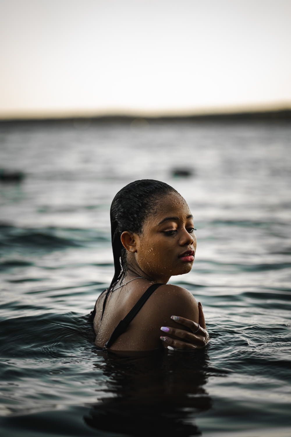 woman in black bikini top in water during daytime