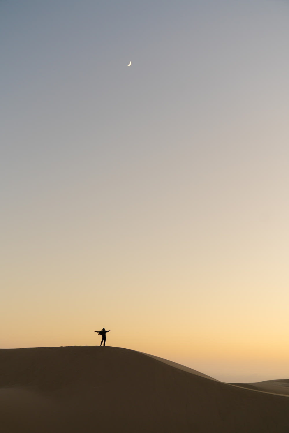 夕暮れ時の砂の上に立つ男のシルエット