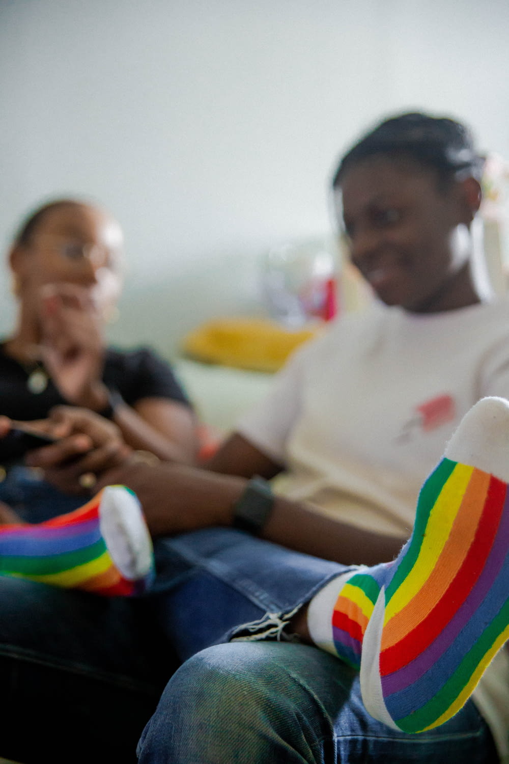women sitting on sofa watching television with rainbow socks