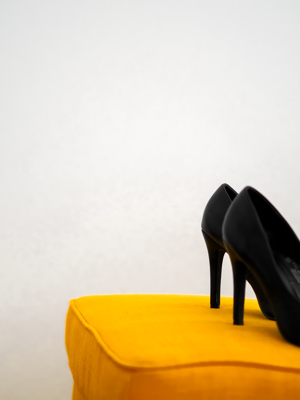 black leather heeled shoes on yellow chair