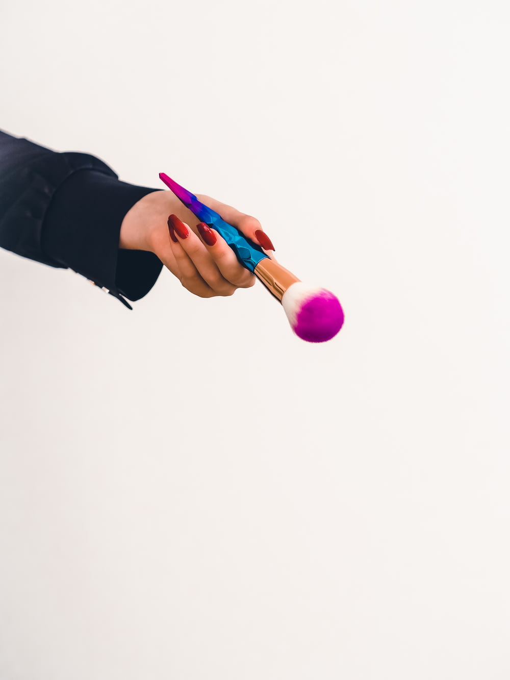 person holding pink and blue plastic toy
