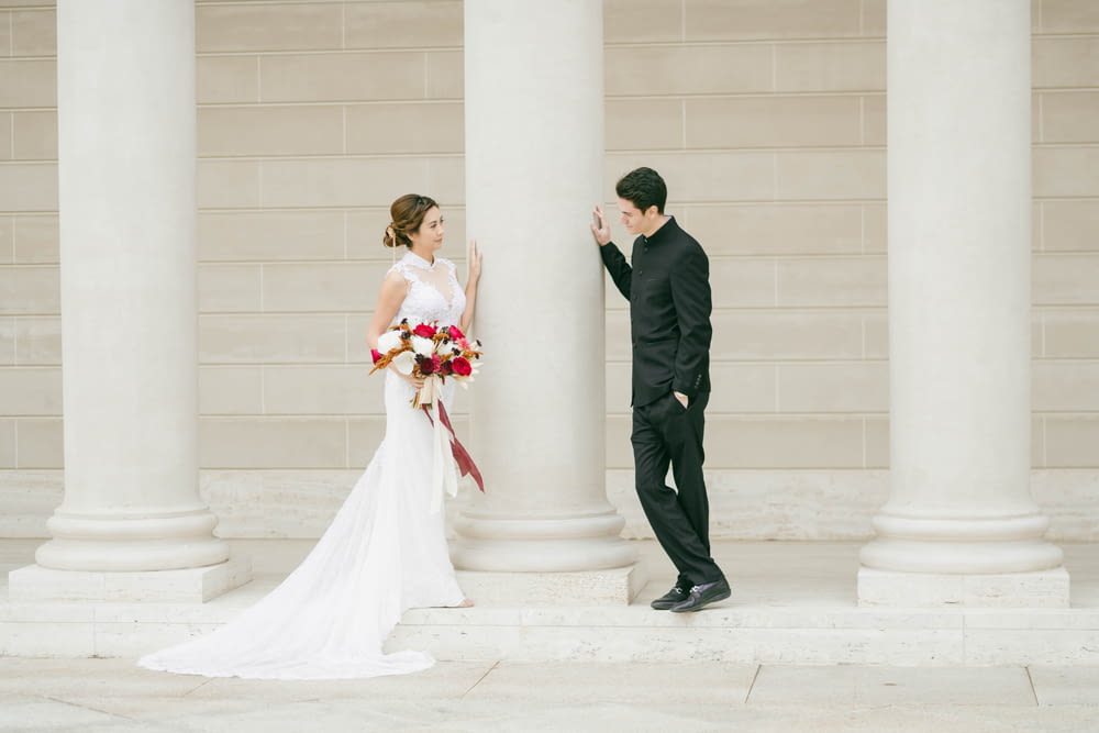 man in black suit and woman in white wedding dress kissing
