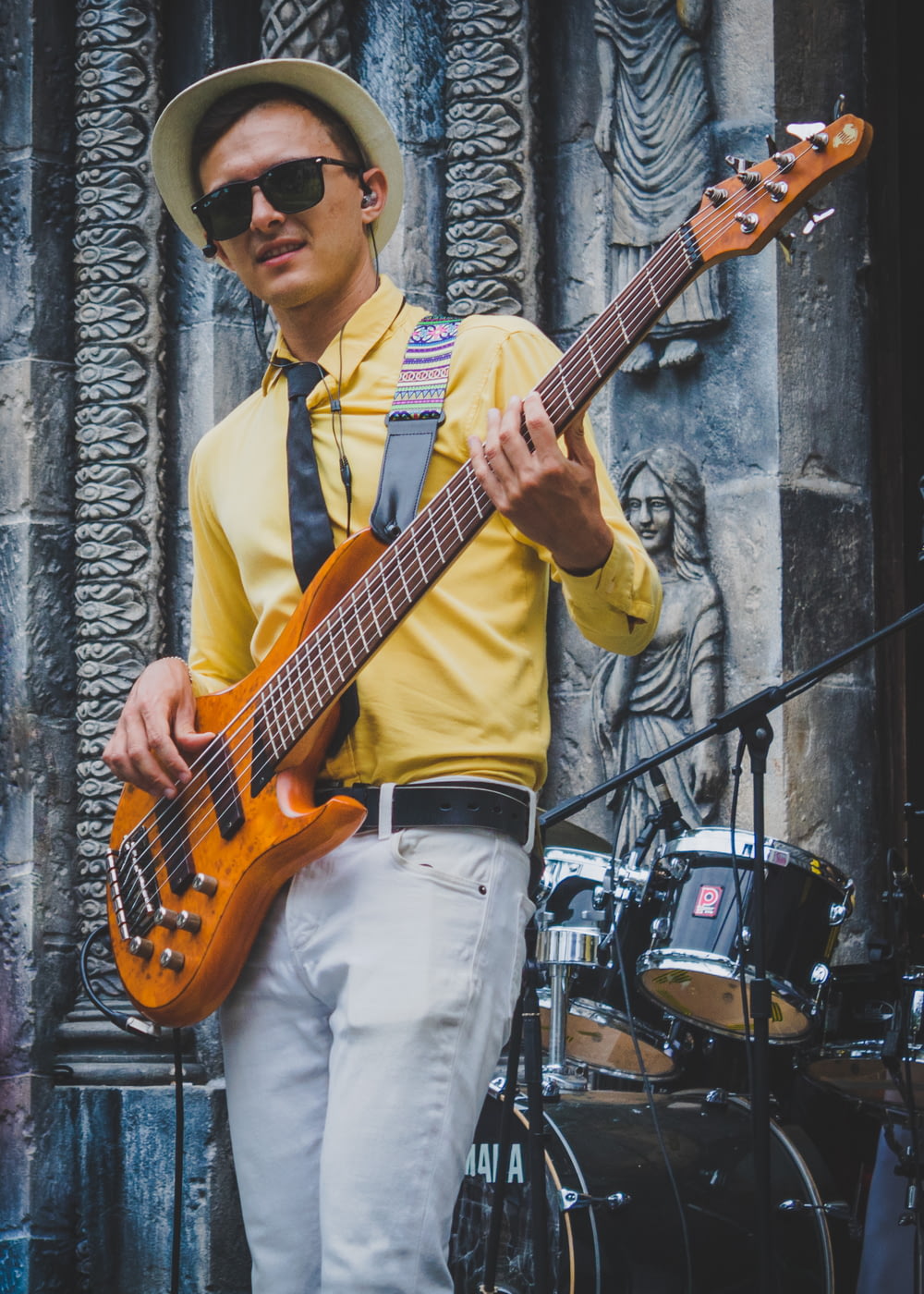 man in yellow polo shirt playing brown electric guitar