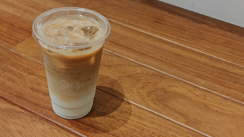 clear plastic cup with brown liquid