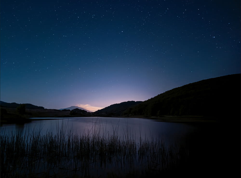 lake and mountain during night time
