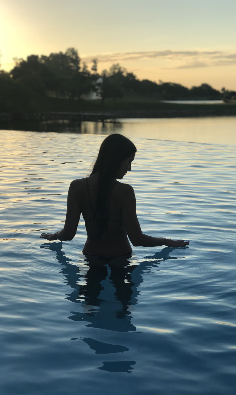 a woman is sitting in the middle of a body of water