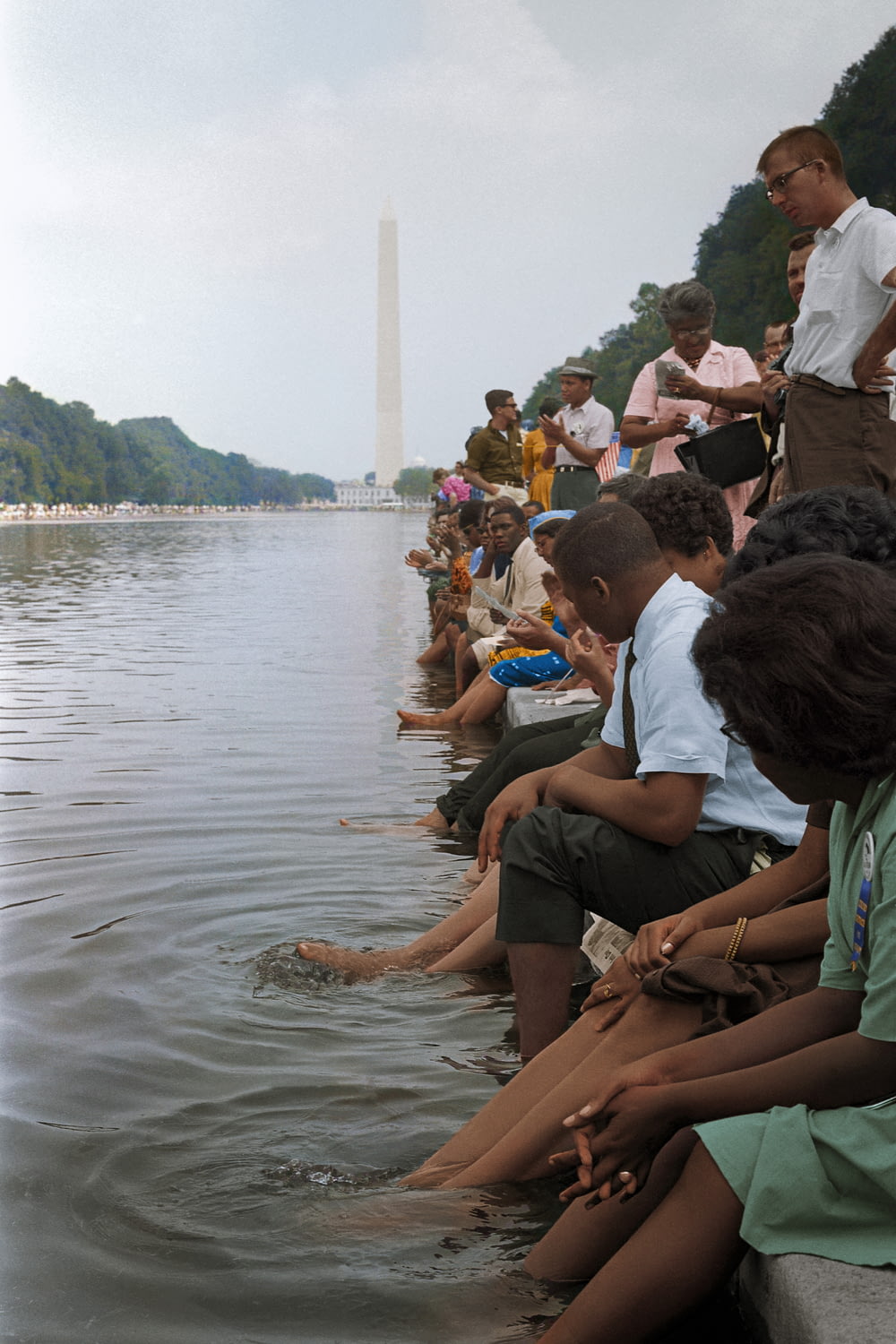 Des manifestants sont assis, les pieds dans le miroir d’eau, lors de la Marche sur Washington en 1963