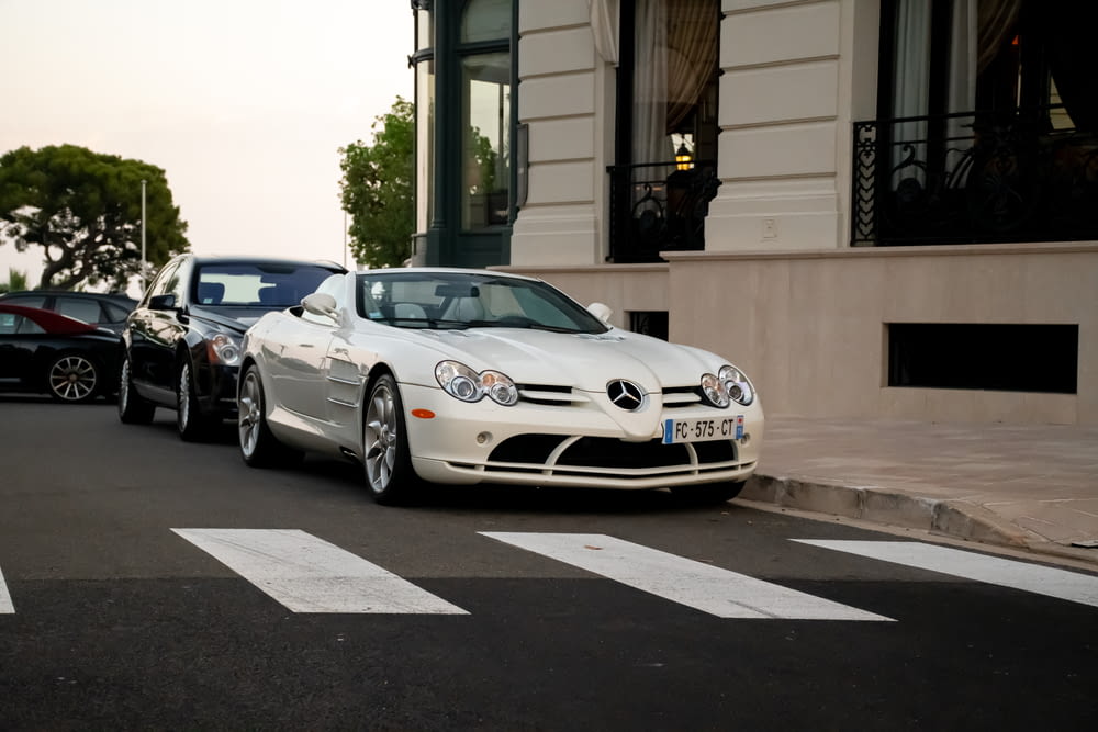 BMW M 3 coupé bianca parcheggiata sul marciapiede durante il giorno
