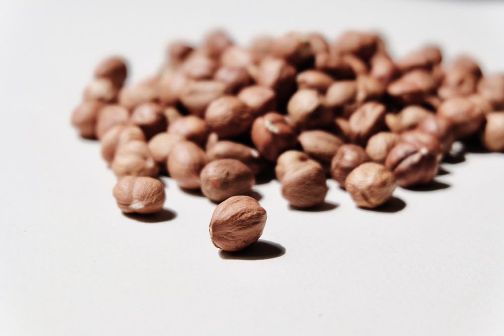 grains de café bruns sur surface blanche