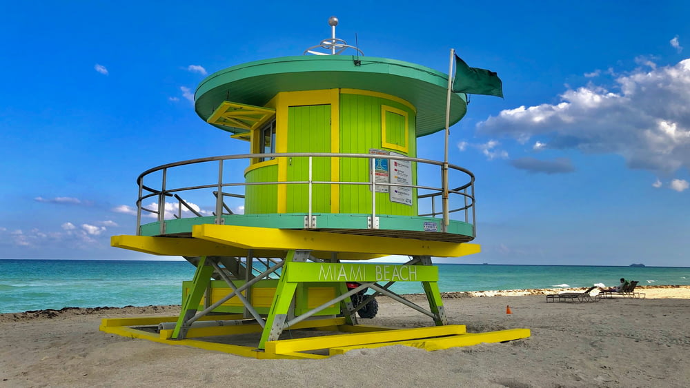 white and yellow lifeguard house on beach during daytime
