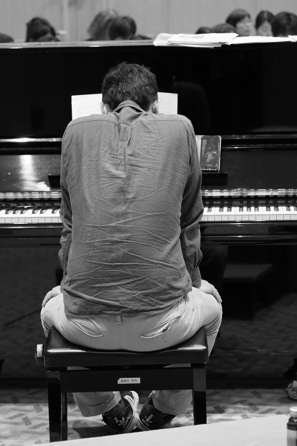 man in long sleeve shirt sitting on piano