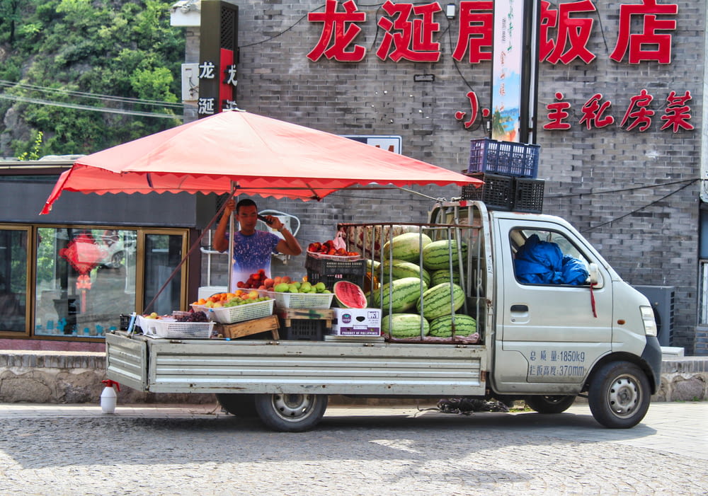white van with fruits and vegetables on top