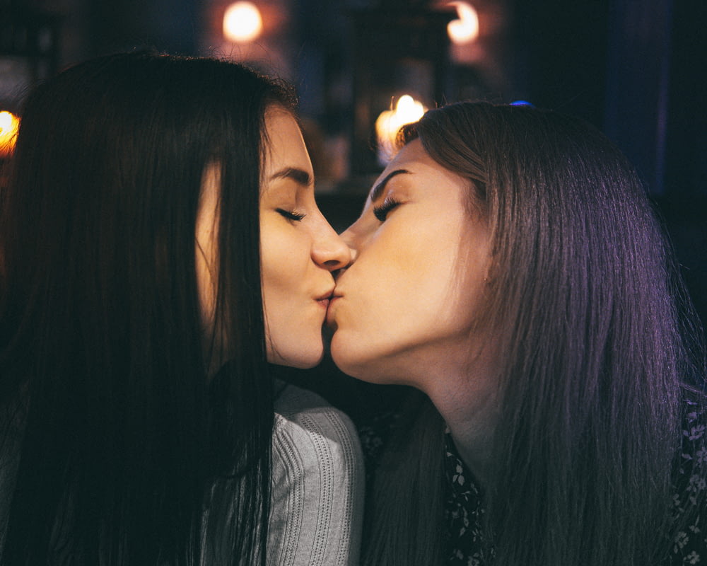 Deux femmes s’embrassent dans une pièce sombre