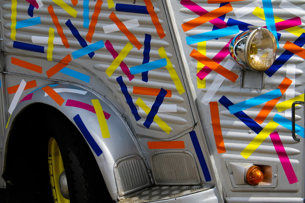 a white truck with colorful streamers painted on it's side