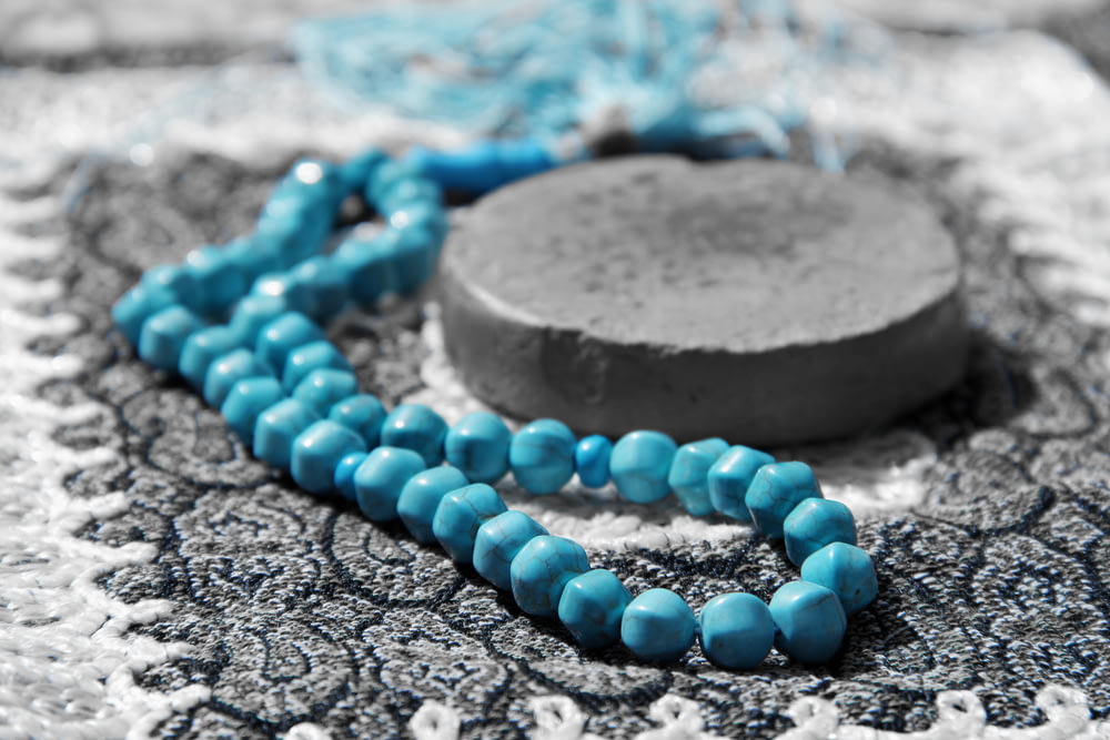 blue beaded bracelet on gray stone