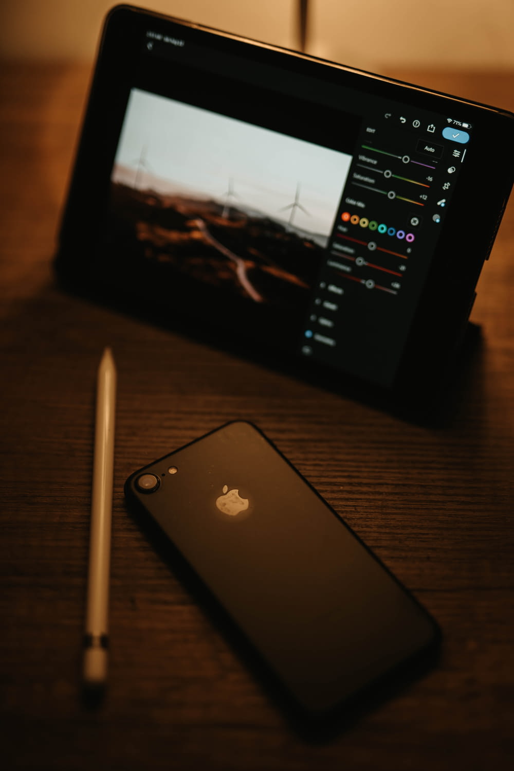 black ipad beside white pen on brown wooden table