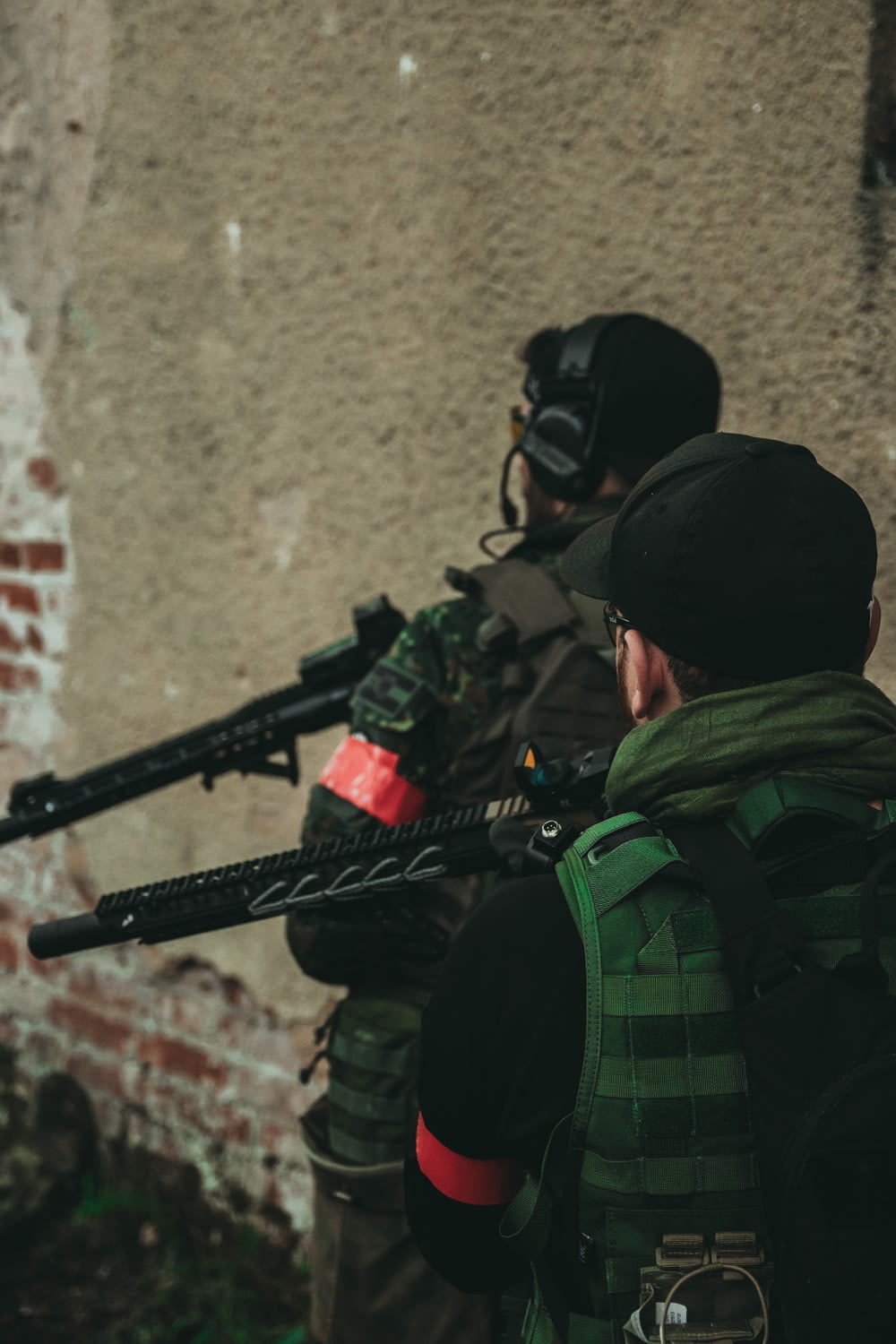 homem em jaqueta de camuflagem verde e preta segurando rifle preto