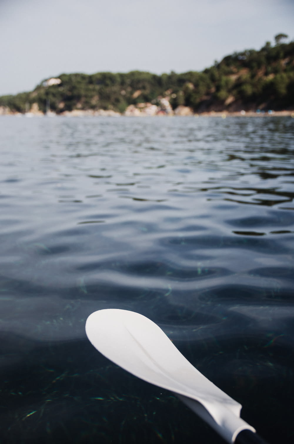 white surfboard on body of water during daytime