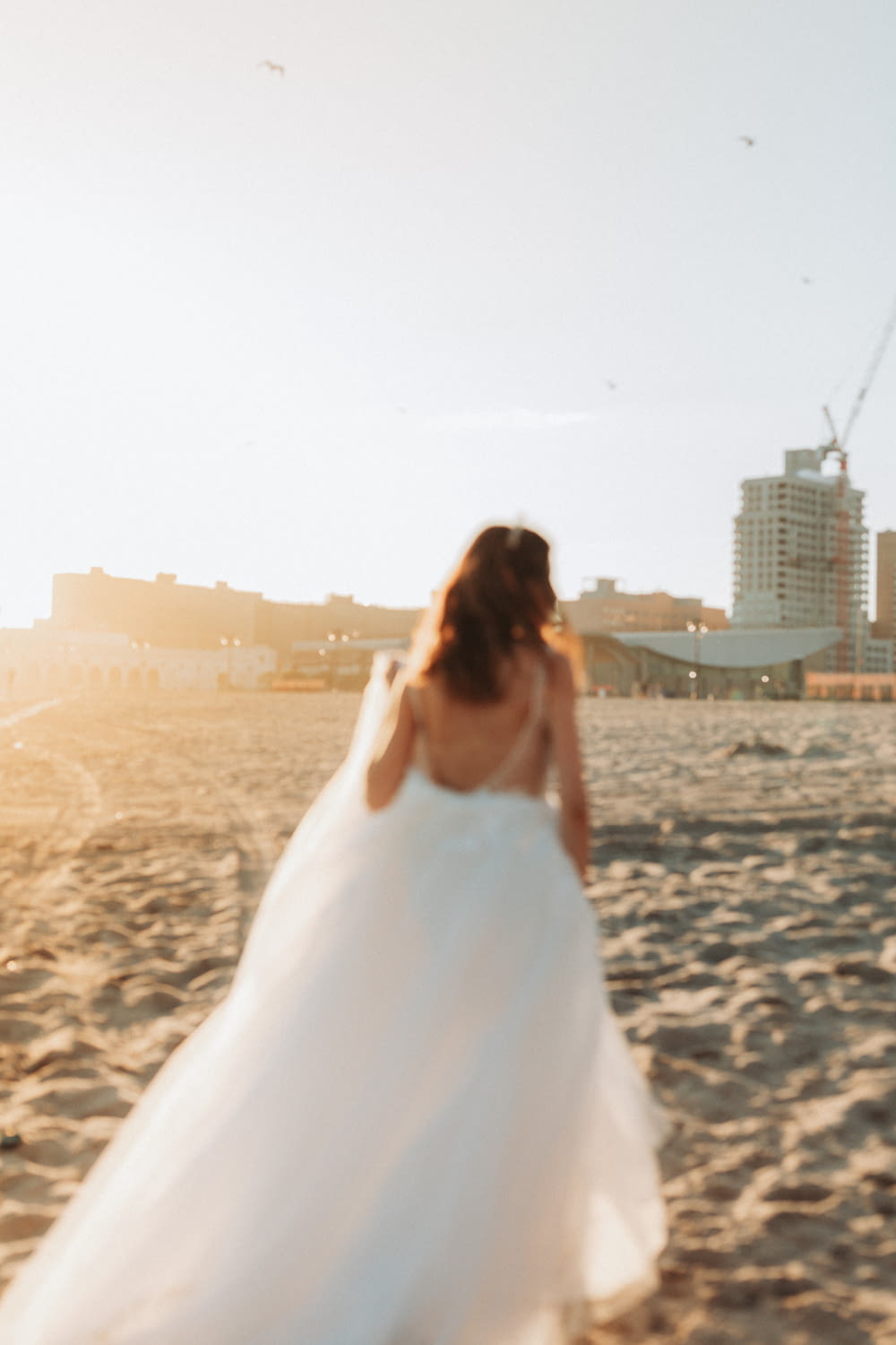 woman in white wedding dress standing on beach during daytime
